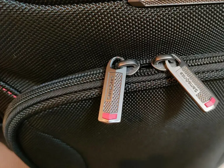 Samsoniteのロゴと赤い部分が付いた黒いバッグのジッパー