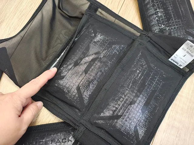 TULTEXの黒メッシュ冷却ベストの保冷剤ポケットを指す手