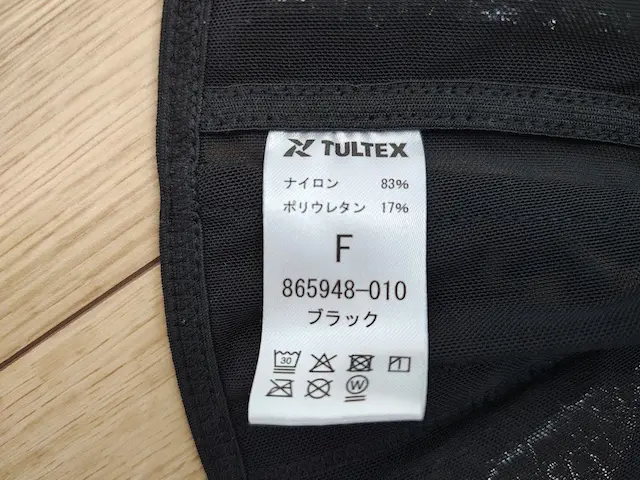 TULTEXブランドの黒い衣類に付く品質表示タグ ナイロン83% ポリウレタン17% サイズF 品番865948-010 ブラック 洗濯マーク
