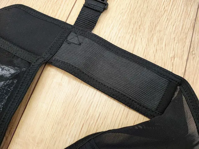 黒いメッシュと伸縮性のあるリブ編み生地で作られた製品のストラップ部分 木目調の床
